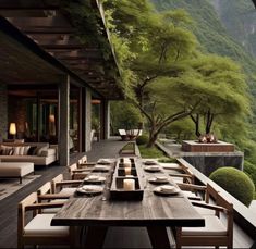 an outdoor dining area with wooden tables and chairs, overlooking the mountain range in the distance