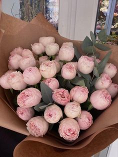 a woman holding a bouquet of pink flowers