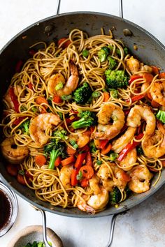 shrimp, broccoli and noodles in a skillet on a white countertop