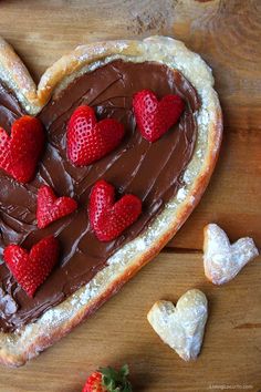 a heart shaped pastry with chocolate frosting and strawberries