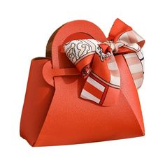 an orange heart shaped purse with a bow