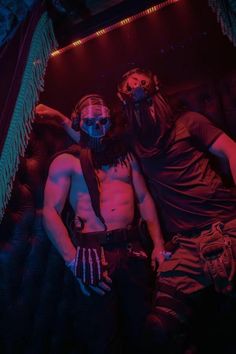 two men in costume standing next to each other with their arms around one another and wearing masks