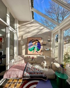 a living room filled with lots of furniture under a skylight next to a window