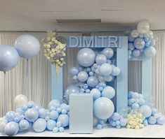 a blue and white backdrop with balloons, flowers, and a sign that says dimter