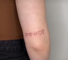 a woman's arm with three small hearts on the left side of her arm