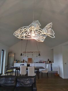 a living room filled with furniture and a large fish chandelier hanging from the ceiling