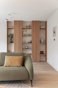 a living room filled with furniture and bookshelves next to a wall mounted book shelf