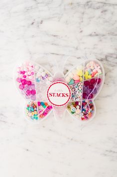 two heart shaped boxes filled with candies on top of a marble countertop next to a sticker that says sticks