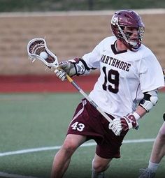 two men in uniforms playing lacrosse on a field