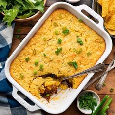 a casserole dish with meat and vegetables in it on top of a wooden table