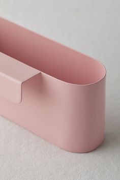 an empty pink container on a white surface