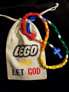 lego and let god beaded bracelets in a drawstring bag on a black background