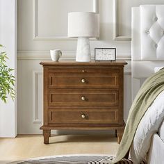 a bedroom scene with focus on the nightstand and bed side table in the foreground