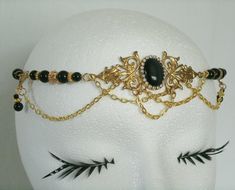 "This beautiful circlet has black glass beads, gold plated accent beads, gold plated chain, brass side accent pieces, brass pendant and black cats eye stone setting with rhinestones. 20\" long can be adjusted to 24\". Lobster clasp." Gold Gothic Wedding Jewelry, Elegant Handmade Gold Body Jewelry, Elegant Handmade Adjustable Body Jewelry, Elegant Black Body Jewelry For Evening, Vintage Gold Crown Headpiece, Gothic Gold Necklace For Wedding, Gold Gothic Necklace For Wedding, Handmade Adjustable Gold Headpiece, Vintage Gold Headpiece For Evening