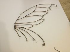 a drawing of a bird's wing on top of a piece of white paper