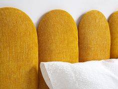 three yellow headboards are next to each other with white sheets on top of them