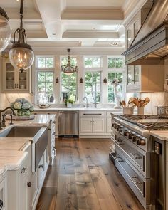 a large kitchen with white cabinets and stainless steel appliances, along with wooden floors that match the hardwood flooring