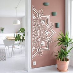 a potted plant sitting on top of a white floor next to a pink wall