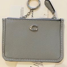 Secure Your Essentials In Style With This Chic Mini Id Case From Coach. Product Details: - Cross-Grained Leather - Credit Card Slot And Id Window - Zip-Top Closure, Fabric Lining - Attached Split Key Ring - 4.25" L X 3" H Imported Material & Care Leather Guaranteed Authentic!! Coach Silver Wallet For Everyday Use, Coach Silver Wallets For Everyday Use, Compact Coach Wallet, Coach Keychain Wallet With Keys, Coach Bags With Silver-tone Hardware In Gray, Coach Shoulder Bag With Silver-tone Hardware For Daily Use, Coach Gray Bag With Silver-tone Hardware, Wallet Shop, Coach Accessories