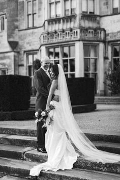 a bride and groom standing on some steps