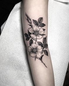 a black and white flower tattoo on the arm