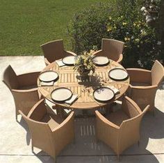 an outdoor table and chairs with plates on it in the middle of a patio area