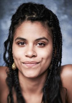 a woman with dreadlocks smiling at the camera