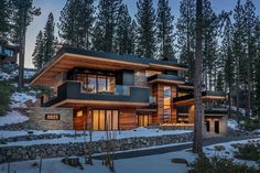 a large house in the woods with snow on the ground