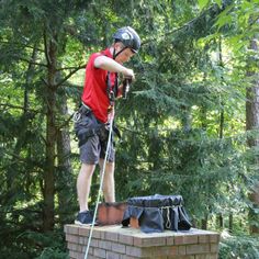 a man standing on top of a brick block structure in the middle of a forest