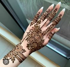 a woman's hand with hennap on it and her hands showing the intricate design