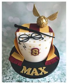 a harry potter birthday cake with glasses, wand and hat on it's top