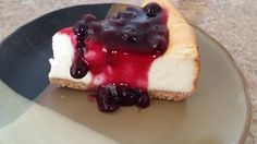 a piece of cheesecake with blueberry sauce on it