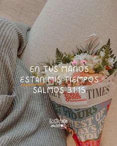 a flower pot sitting on top of a couch next to a sweater and pillow with the words, en tus manos est mis tempros salmos salmos