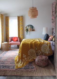 a bed room with a neatly made bed and yellow curtains