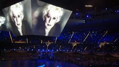 the stage is lit up with blue lights and two large screen screens showing marilyn monroe