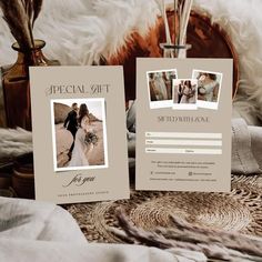 two wedding cards with photos on them sitting next to a basket filled with flowers and feathers