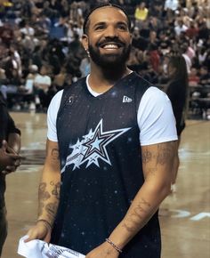 a man standing in front of a crowd wearing a black and white shirt with a star on it