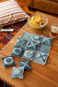 a wooden table topped with pillows and bowls of food next to a bowl of chips