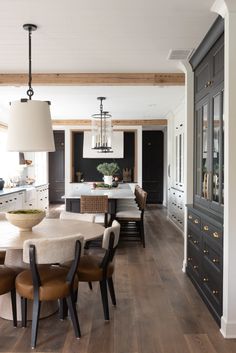 a dining room and kitchen area with wood flooring