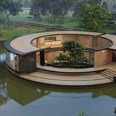 the circular house is surrounded by water and trees