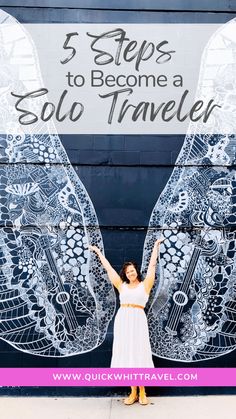 a woman standing in front of a mural with her arms up