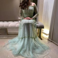 a woman is sitting on a bench wearing a dress with sequins and beads