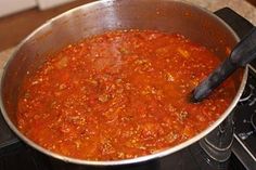 a pot full of chili sitting on top of a stove