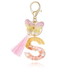 a pink and yellow keychain with a butterfly on it's back, hanging from a hook