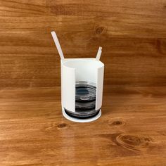 a cup with two straws in it sitting on a table