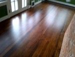 an empty living room with wood floors and green walls