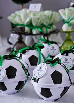 soccer balls are sitting on a table with green ribbons