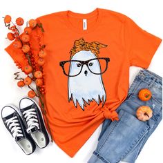 an orange t - shirt with a white ghost wearing glasses and a bow on its head