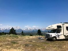 an rv parked on the side of a road with mountains in the background