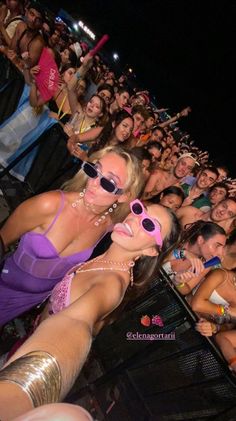 a group of people sitting next to each other in front of a crowd at a concert